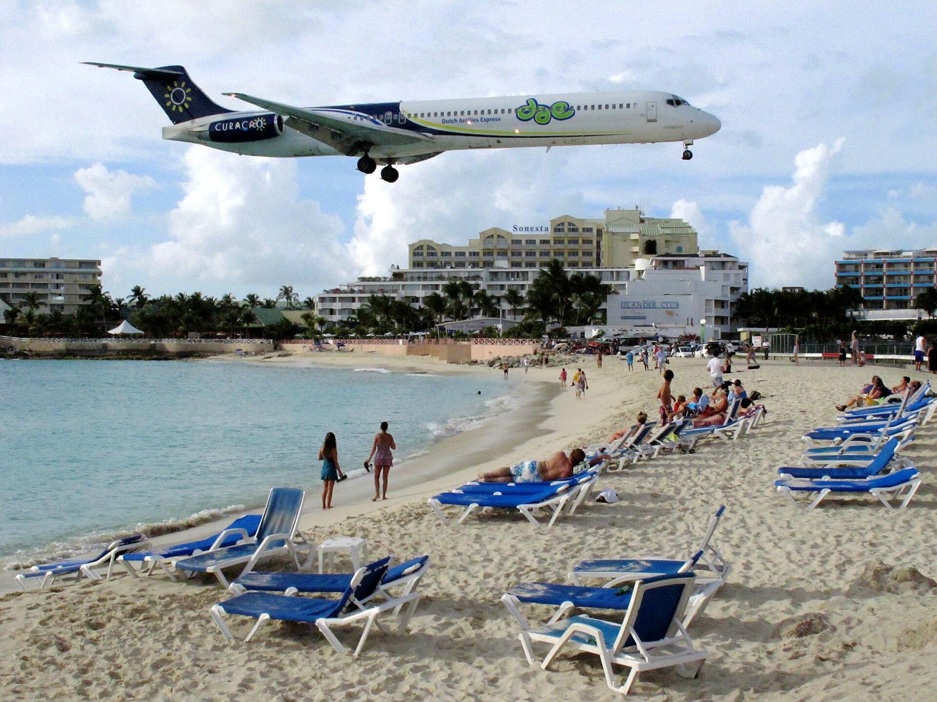A jet descending above the sand and turquoise water at Maho Beach on Sint Maarten