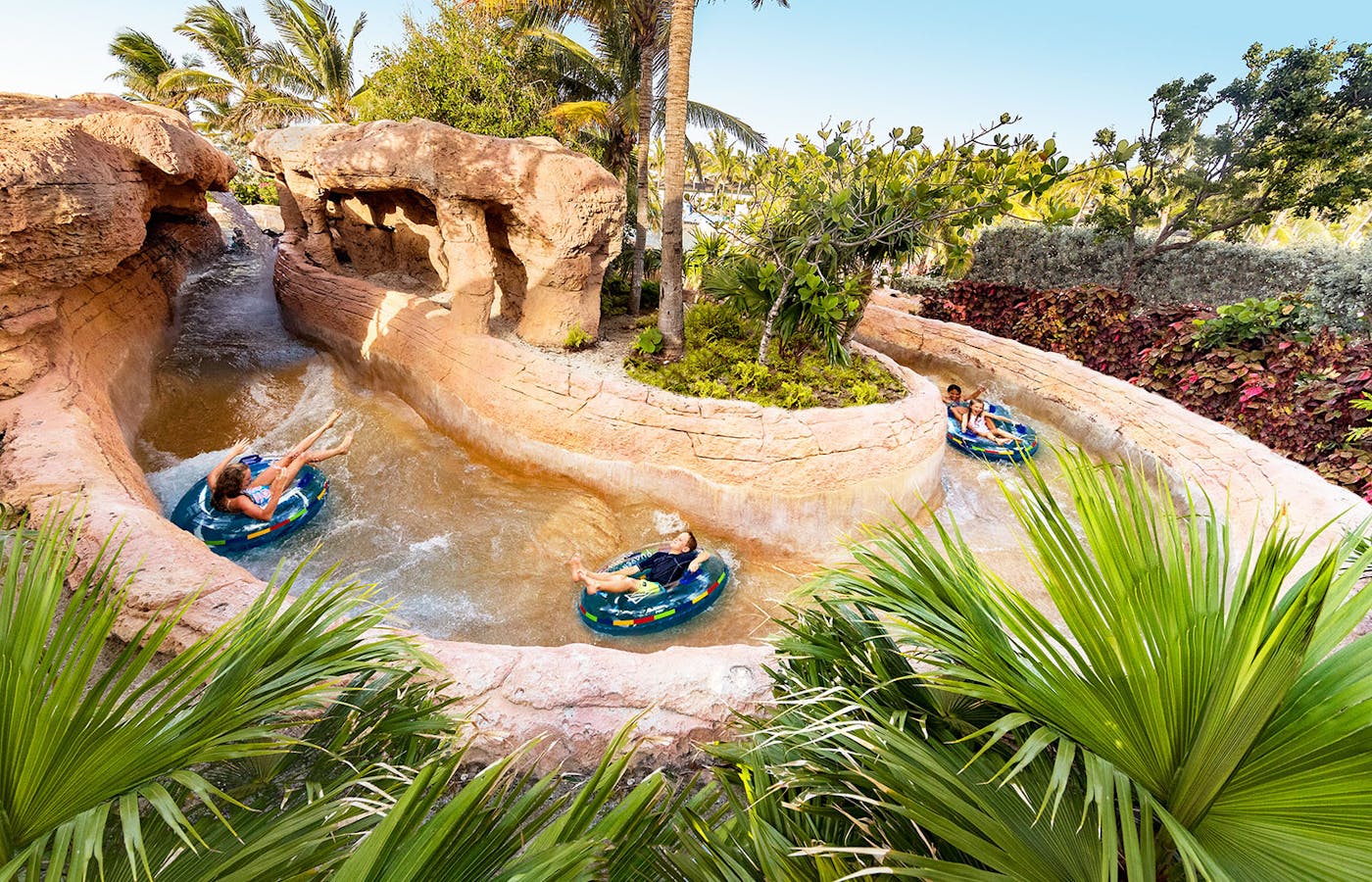 Guests riding inner tubes through the Rapids River at Atlantis Aquaventure
